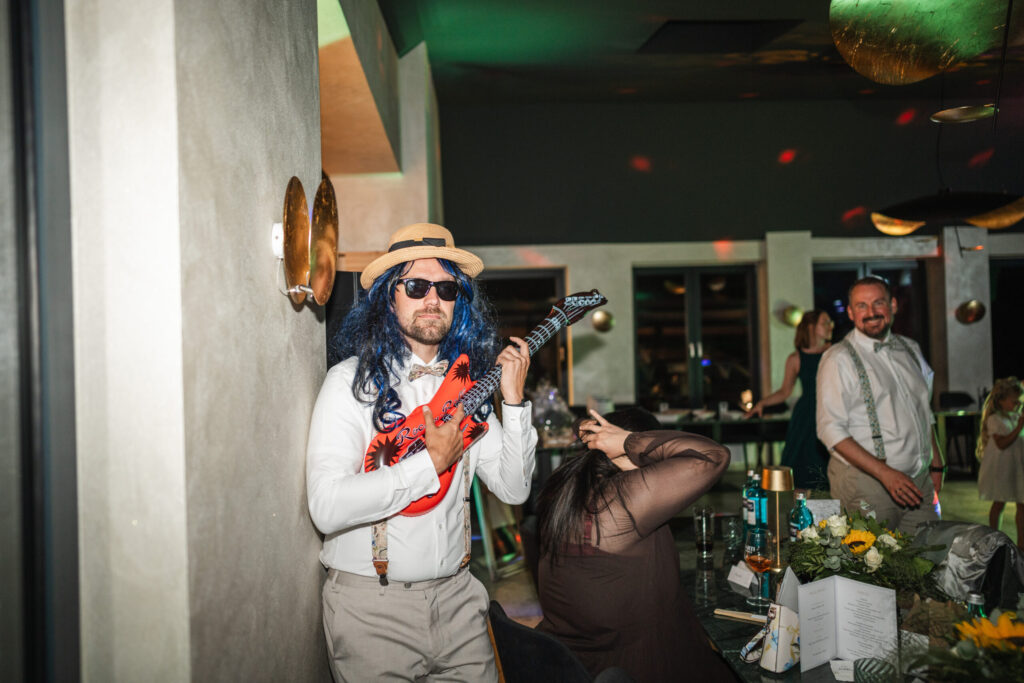 Gast bei Hochzeit im Casa al Mare mit aufblasbarer Gitarre
