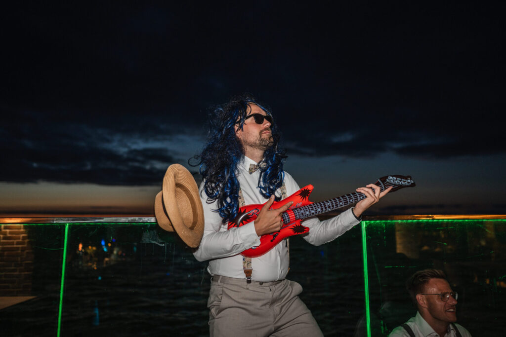 Gast bei Hochzeit im Casa al Mare mit aufblasbarer Gitarre